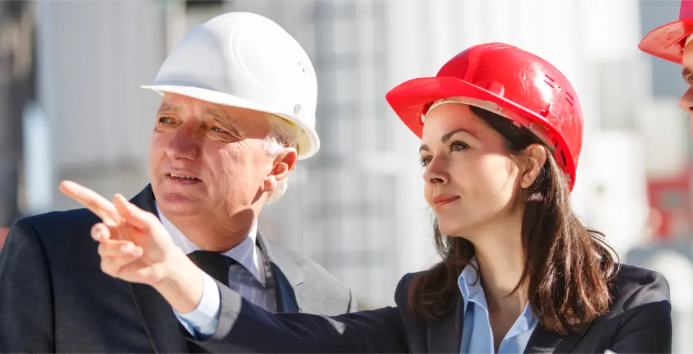 Two professionals discussing facility management, one pointing to demonstrate a concept